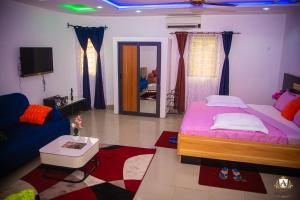 a bedroom with a large bed and a living room at Hôtel Akwin Kpalimé in Palimé
