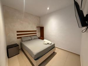 a small bedroom with a bed and a television at Casa Villa Leo in Cancún