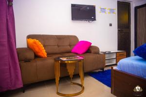 a living room with a couch and a table at Hôtel Akwin Kpalimé in Palimé +6 photos