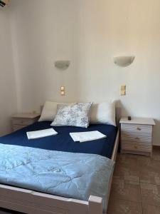 a bedroom with a blue bed with two pillows at Vista del Mare Rooms 2 in Agios Ioannis Kaspaka