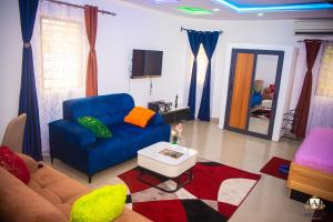a living room with a blue couch and a table at Hôtel Akwin Kpalimé in Palimé