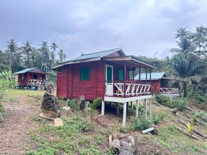 a small red house with a porch on a hill at Conjá Ecolodge in Porto Alegre +6 photos