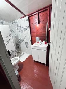 a bathroom with a white toilet and a sink at Conjá Ecolodge in Porto Alegre
