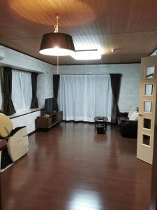 a large living room with a couch and a tv at Villa9 in Onjuku