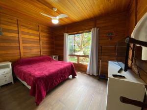 a bedroom with a red bed and a window at Paz e Conforto na Serra Pet Friendly in Teresópolis +42 photos