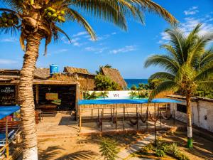 a view of a resort with palm trees and the ocean at Wild Rover Beach Mancora in Máncora