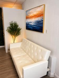 a white couch in a room with a painting at The orlando oasis in Orlando +1 photo