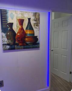 a painting of three vases on a wall next to a door at The orlando oasis in Orlando