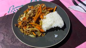 a plate of food with rice and vegetables on a table at Nukuwasiga homestay in Soso