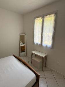 a bedroom with a bed and a table and a mirror at Pavillon Le Luc in Ozillac