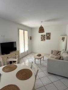 a living room with two tables and a couch at Pavillon Le Luc in Ozillac