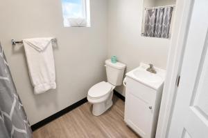 a white bathroom with a toilet and a sink at Rocky Mount Motel near Hwy 220 in Rocky Mount +9 photos
