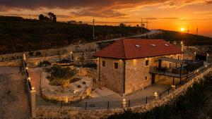a building with a red roof with a sunset in the background at Fagundes Village in Valença