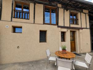a patio with a table and chairs in front of a building at Les Petits Champs Islandais in Manas-Bastanous