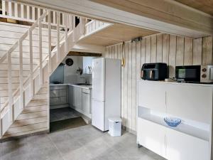 a kitchen with white cabinets and a staircase at Les Petits Champs Islandais in Manas-Bastanous