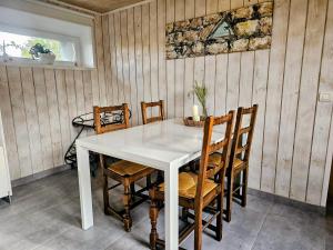 a dining room with a white table and chairs at Les Petits Champs Islandais in Manas-Bastanous