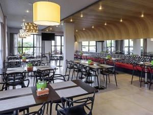 a dining room with tables and chairs in a restaurant at ibis Styles Birigui in Birigui