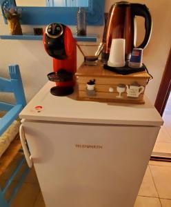 a coffee maker on the top of a refrigerator at Palmas Anna's rooms Is Procilis in Palmas Arborea