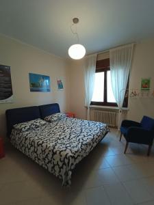 a bedroom with a bed and a large window at Appartamento in villa con vista Monviso in Piossasco