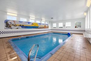a large swimming pool with blue water in a room at Surfside Resort in Rockaway Beach