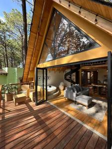 a large wooden deck with a large glass window at Cabañas VIP in Mazamitla