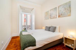 a bedroom with a large white bed with a green blanket at Lisbon Design Flat, Luxury, 7 People, Pool Garden in Lisbon