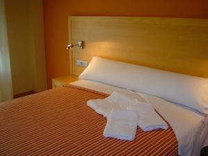 a bedroom with a bed with two towels on it at Apartamentos Esperanza del Mar in Portonovo