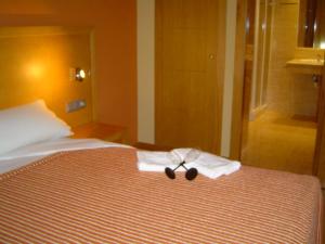 a pair of scissors sitting on top of a bed at Apartamentos Esperanza del Mar in Portonovo