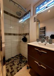 a bathroom with a sink and a shower at La Ch'tite Maison in Masnières