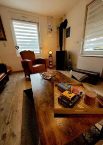 a living room with a wooden table and chairs at La Ch'tite Maison in Masnières +8 photos