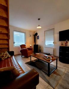 a living room with a couch and a coffee table at La Ch'tite Maison in Masnières