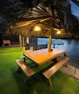 a wooden table and benches under a large umbrella at Vila dos Poetas in Barreirinhas