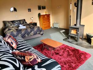 a living room with a couch and a wood stove at The Shed in Manapouri