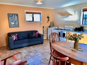 a living room with a table and a blue couch at The Shed in Manapouri