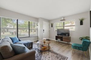 a living room with a couch and a tv at Amazing 2BR Queen 8mins SODO & 4mins ORMC in Orlando