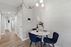 a dining room with a table and blue chairs at Amazing 2BR Queen 8mins SODO & 4mins ORMC in Orlando +9 photos