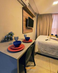 a room with two bowls on a table with a bed at Uno Flats - By EasyHost in Tambaú