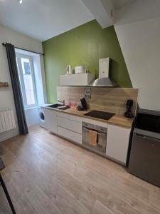 a kitchen with a sink and a stove top oven at Le Club Philibert in Auxerre +1 photo