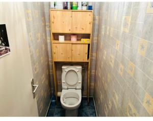 a small bathroom with a toilet with wooden shelves at V hotel in Savigny-le-Temple +4 photos