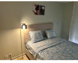 a bedroom with a bed and a lamp in it at V hotel in Savigny-le-Temple