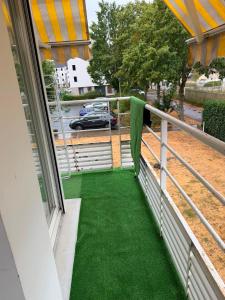 a balcony with green flooring and a view of a car at V hotel in Savigny-le-Temple