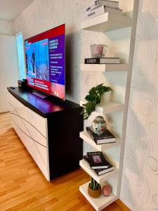a living room with a tv on a shelf at V hotel in Savigny-le-Temple