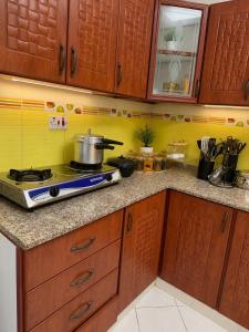 a kitchen with wooden cabinets and a stove at Iman Guest House in Al Qurayyah