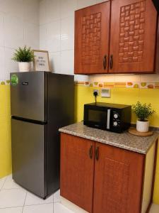 a kitchen with a stainless steel refrigerator and a microwave at Iman Guest House in Al Qurayyah +11 photos