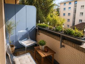a balcony with a chair and a table and some plants at Chambre Lac Rose in Lausanne