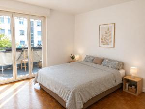 a bedroom with a bed and a large window at Chambre Lac Rose in Lausanne