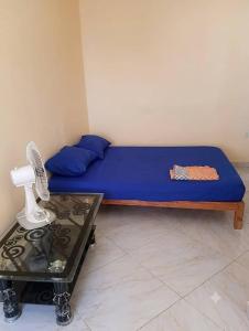 a small bedroom with a blue bed and a table at Dar mouni relax in Oran
