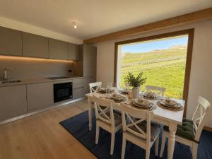 a dining room with a table and a large window at Résidence Phoenix C by Leavetown Vacations in L'Alpe-d'Huez