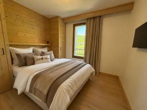 a bedroom with a large bed and a window at Résidence Phoenix C by Leavetown Vacations in L'Alpe-d'Huez
