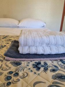 a bed with a pile of towels on the floor at Gościniec Joanna in Rajgród
